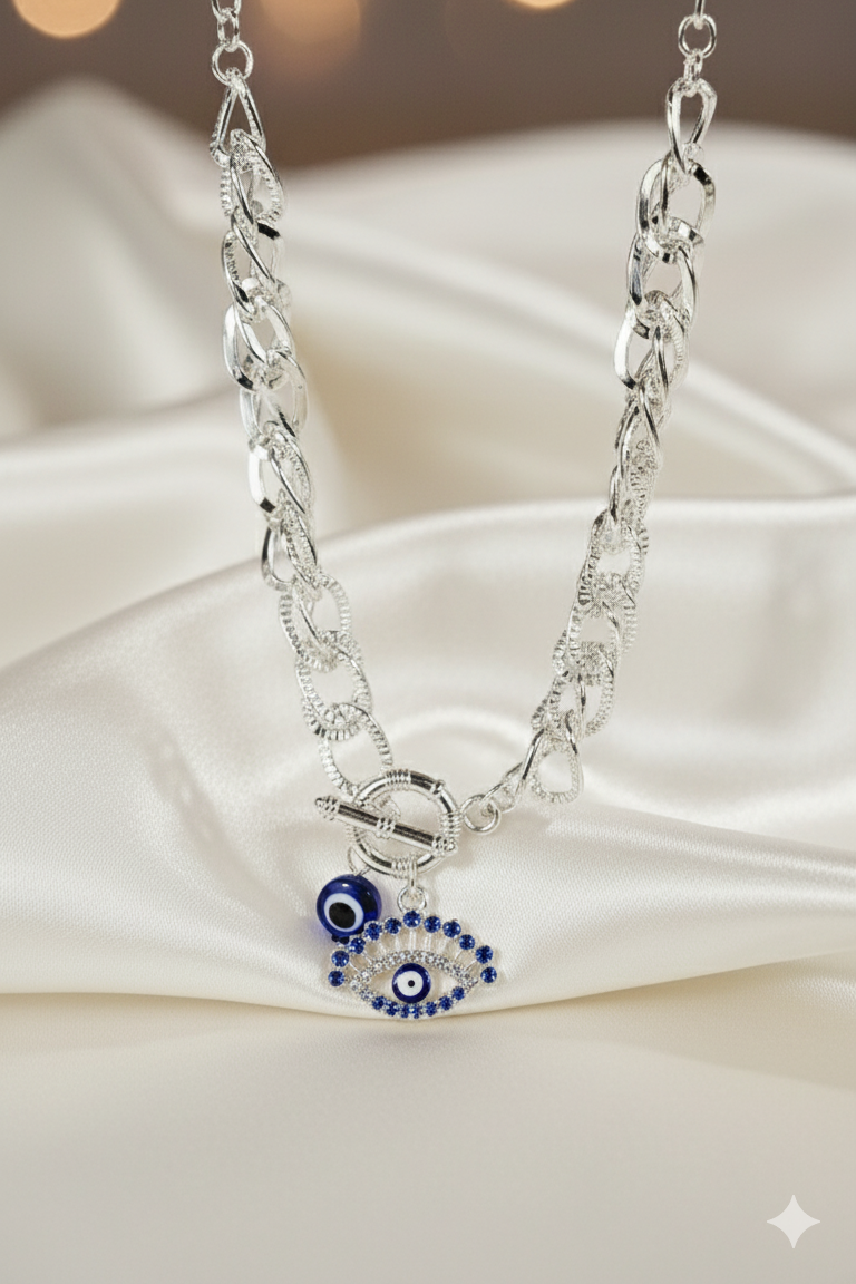 Silver necklace with an eye-shaped pendant on a white fabric background