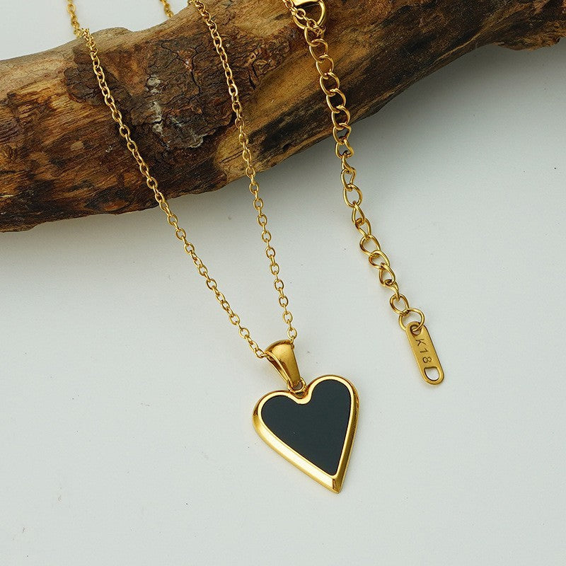 Three heart-shaped pendants on gold necklaces displayed on a gold stand against a white background.