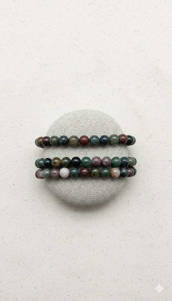 Two beaded bracelets on a gray stone with a light gray background